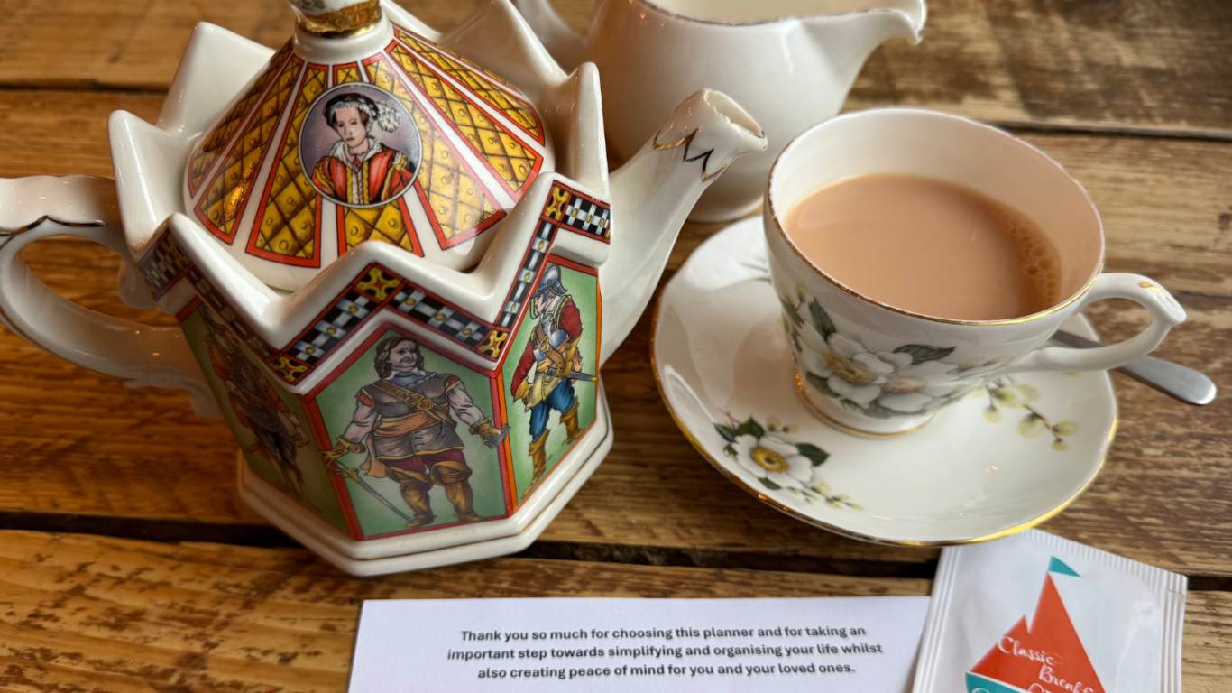 Image shows an ornate teapot, milk jug and cup of tea along with a welcome note and a complimentary teabag Jayne sends out with her planner